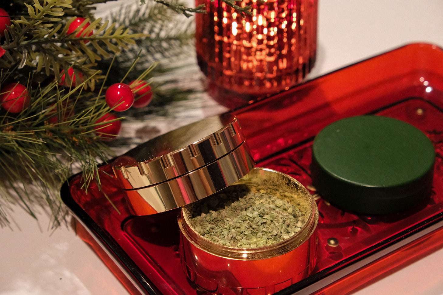 Keefer Reaper Gold 4 Piece stainless steel grinder on a red tray with shredded product inside. Mistletoe is on the top left corner.