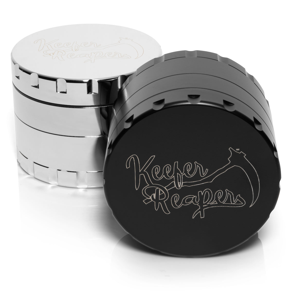 Black and Silver Stainless Steel Spice and Herb Grinder. Silver Grinder is behind the black grinder. Black grinder is laying down. Keefer Reaper logo prominent on both grinders.